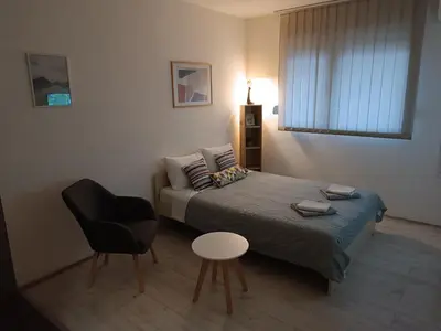 a small bedroom with a bed and a chair at Sleep&Go in Belgrade