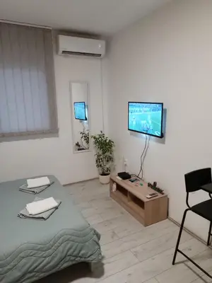a living room with a bed and a flat screen tv at Sleep&Go in Belgrade