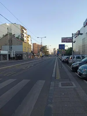 an empty street with parked cars in a city at Sleep&Go in Belgrade