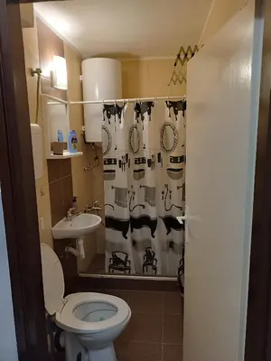 a bathroom with a toilet and a sink and a shower curtain at Sleep&Go in Belgrade