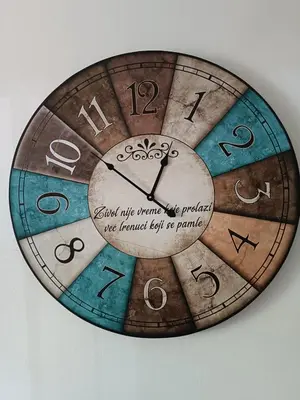 a wooden clock with writing on it on a wall at Sleep&Go in Belgrade