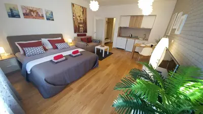 a bedroom with a bed and a living room at Apartments Delta A Blok - Savada in Belgrade