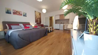a bedroom with a bed and a living room at Apartments Delta A Blok - Savada in Belgrade
