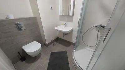 a bathroom with a shower and a toilet and a sink at Apartments Delta A Blok - Savada in Belgrade