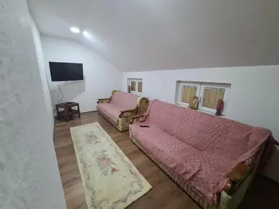a living room with a couch and a tv at Apartmani Mladenović in Kijevo