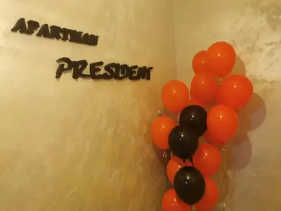 a bunch of orange and black balloons next to a wall at President app Arandjelovac in Arandjelovac