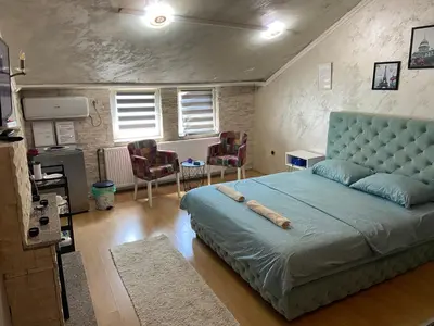 a bedroom with a large bed with a blue headboard at President app Arandjelovac in Arandjelovac