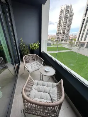 a balcony with two wicker chairs and a table at Belgrade Waterfront Escape 104 in Belgrade
