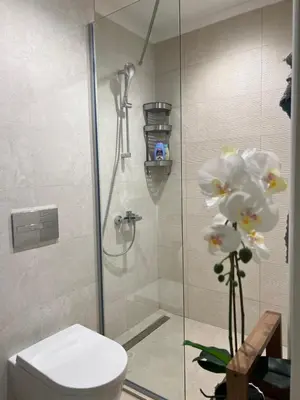 a bathroom with a shower with a toilet and flowers at Belgrade Waterfront Escape 104 in Belgrade