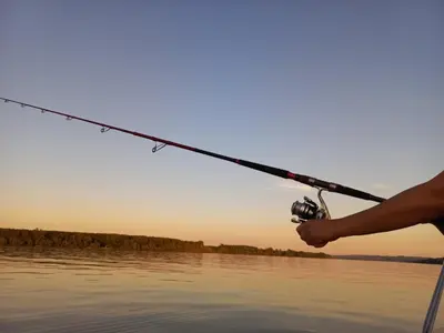 a person holding a fishing rod on the water at Bora kuće na reci in Belgrade
