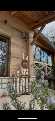 a clock on the side of a house with flowers at Bora kuće na reci in Belgrade