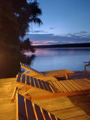 a row of chairs sitting on a dock on a lake at Bora kuće na reci in Belgrade