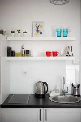 a kitchen counter with a sink and shelves with dishes at You will love it, in Vracar in Belgrade