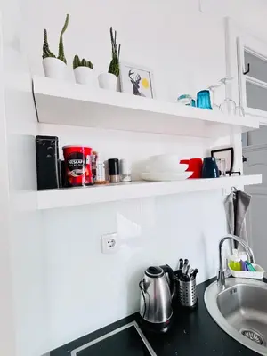 a kitchen counter with shelves above a sink at You will love it, in Vracar in Belgrade