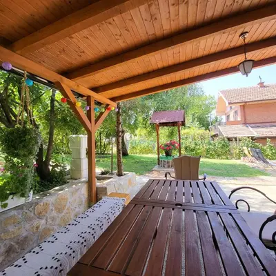 a wooden deck with a bench and a gazebo at Vila Mila Fruška Gora in Velika Remeta