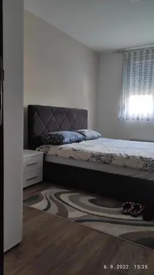 a bedroom with a bed and a window and a rug at Centar_park in Arandjelovac