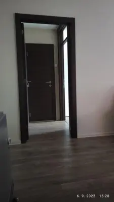 an empty room with a black door and wooden floors at Centar_park in Arandjelovac