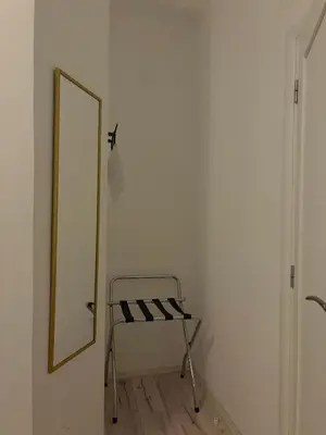 a mirror and a chair in a room at MiniCity Inn in Belgrade
