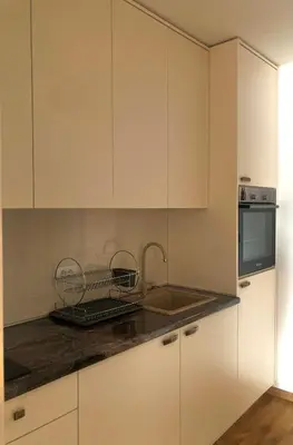 a kitchen with white cabinets and a sink at MiniCity Inn in Belgrade