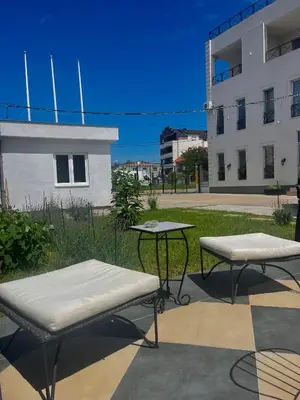 two tables and benches in front of a building at MiniCity Inn in Belgrade