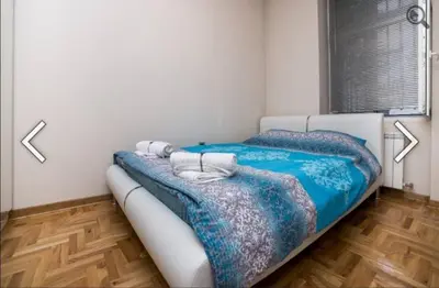 a bedroom with two beds with blue sheets at Višegradska in Sajmište