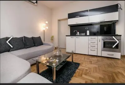 a living room with a couch and a table and a kitchen at Višegradska in Sajmište
