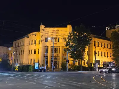 a large white building on a city street at night at Angelina 03. in Belgrade