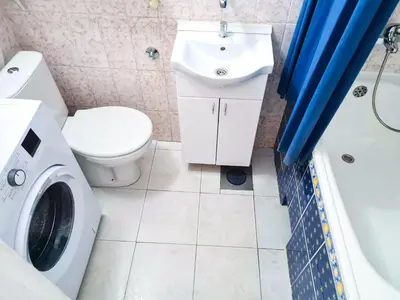 a bathroom with a toilet sink and a washing machine at Angelina 03. in Belgrade