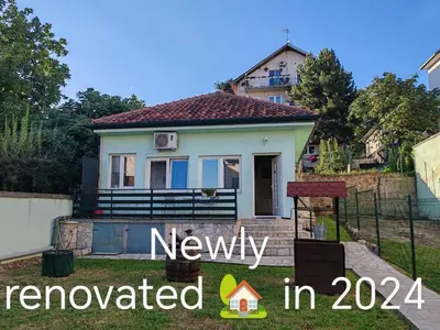 a small house with a sign that reads newly renovated at Cozy green house (free parking spot) in Belgrade