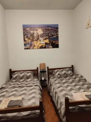 two beds sitting next to each other in a bedroom at Cozy green house (free parking spot) in Belgrade