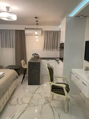 a room with a bed and a kitchen with a table at Liga apartment in Vračar (historical)