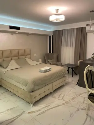 a bedroom with a bed and a table and chairs at Liga apartment in Vračar (historical)