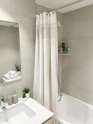 a bathroom with a white shower curtain and a sink at Lolita Lux - Belgrade Waterfront in Belgrade