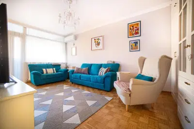 a living room with a blue couch and two chairs at Sava Centar 1-bedroom apartments in the heart of New Belgrade in Belgrade