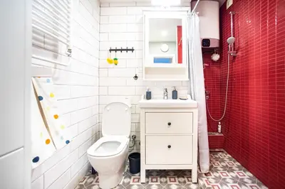 a bathroom with a toilet and a sink and red tiles at Sava Centar 1-bedroom apartments in the heart of New Belgrade in Belgrade