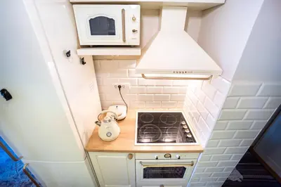 a small kitchen with a stove and a microwave at Sava Centar 1-bedroom apartments in the heart of New Belgrade in Belgrade