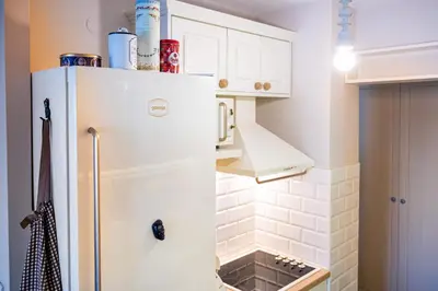 a kitchen with a white refrigerator in a room at Sava Centar 1-bedroom apartments in the heart of New Belgrade in Belgrade