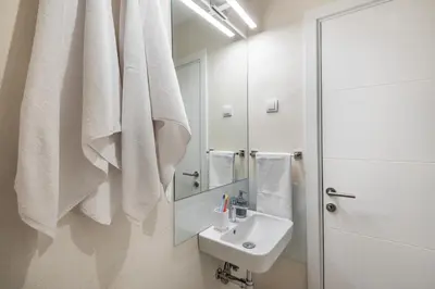 a white bathroom with a sink and a mirror at Apartment Vracar Belgrade, St Sava Church Park in Belgrade