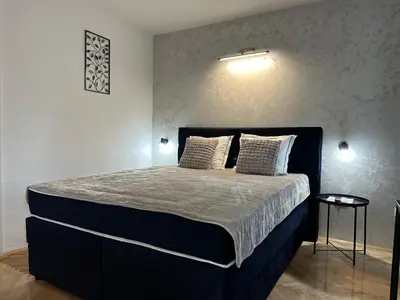 a bedroom with a large bed with two pillows at Aster Apartments in Belgrade