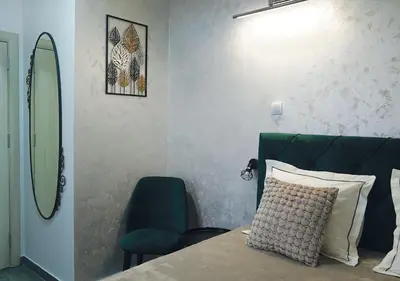 a bedroom with a bed with a mirror and a chair at Aster Apartments in Belgrade