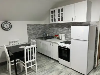 a kitchen with a white refrigerator and a table with chairs at Aster Apartments in Belgrade