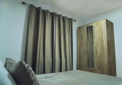 a bedroom with a bed and a wooden cabinet at Aster Apartments in Belgrade