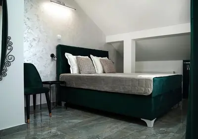 a bedroom with a green bed with a mirror at Aster Apartments in Belgrade