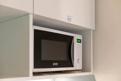 a microwave oven in a shelf in a kitchen at City Passage Apartments in Belgrade