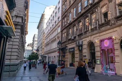 a group of people walking down a street with buildings at City Passage Apartments in Belgrade