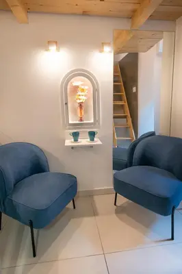 two blue chairs in a waiting room with a staircase at City Passage Apartments in Belgrade