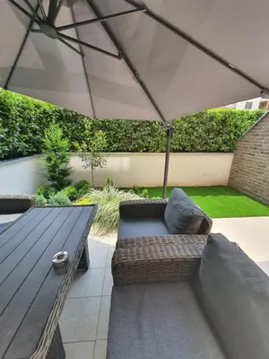 a patio with a wooden table and an umbrella at Garden House Lux in Belgrade