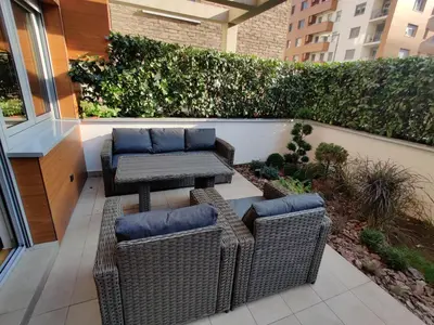 a patio with two wicker chairs and a table at Garden House Lux in Belgrade