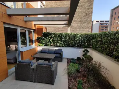 a patio with wicker chairs and a table on a building at Garden House Lux in Belgrade