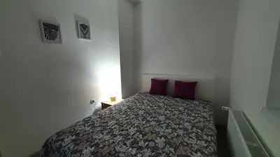 a small bedroom with a bed with red pillows at IMPERIUM stan na dan in Inđija